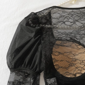 Détail de dentelle florale noire avec manches bouffantes et maille transparente chic