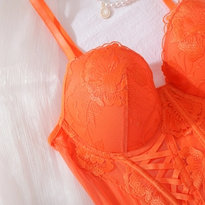 Close-up of orange floral embroidery lace corset with underwire and cross strap detail
