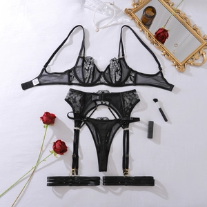 Detailed view of sheer floral embroidery and gold hardware on black lace lingerie set