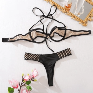 Dettaglio del set di lingerie in rete nera con reggiseno a fascia e slip a strisce