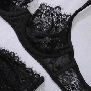 Detailed macro shot of intricate black eyelash lace and floral mesh texture on bra cup