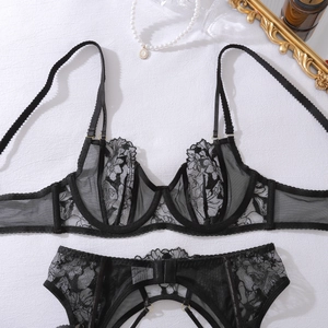 Detailed close-up of sheer black floral embroidery lace and adjustable gold rings