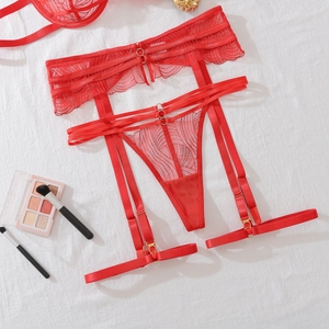 Détail de l'ensemble porte-jarretelles en dentelle rouge avec boucles dorées