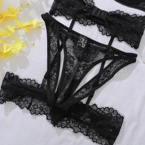 Flat lay of black floral lace lingerie set with gold buckles and garter details