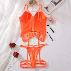 Flat lay of bright orange floral lace lingerie set with suspender belt and accessories