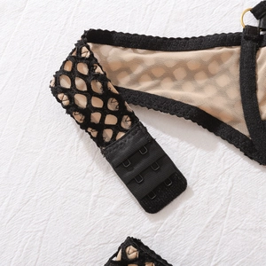 Dettaglio della chiusura a tre file su lingerie in pizzo con mesh e anelli in metallo oro