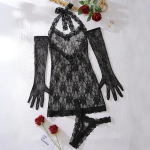 Macro shot of black sheer floral lace lingerie set with matching gloves on white fabric
