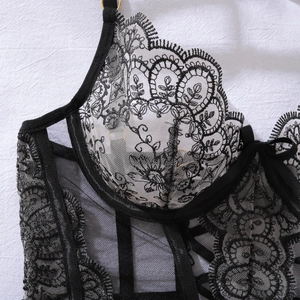 Gros plan détaillé sur la broderie florale et le tulle transparent sur ce corset sexy