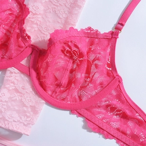 Gros plan du soutien-gorge en dentelle rouge rose avec broderie florale et détails dorés