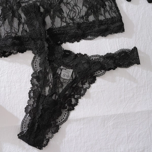 Detailed close-up of sheer floral lace texture and eyelash fringe on black lingerie set