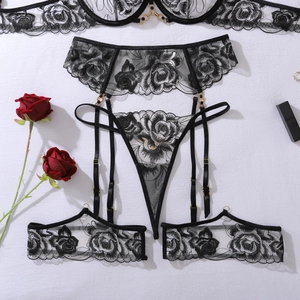 Détail de broderie florale sur ensemble de lingerie en dentelle noire et fleurs