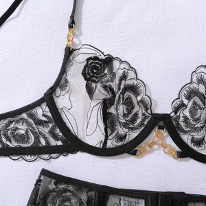 Détails de broderie florale sur lingerie en dentelle avec chaînes dorées élégantes