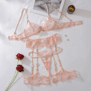 Détail d'un ensemble de lingerie en dentelle pêche avec broderies et porte-jarretelles