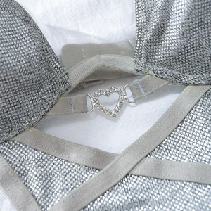 Détail macro d'un ensemble lingerie argenté scintillant avec boucle cœur en strass