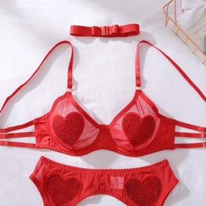Détail de lingerie en résille rouge avec strass coeur et accessoire nœud délicat