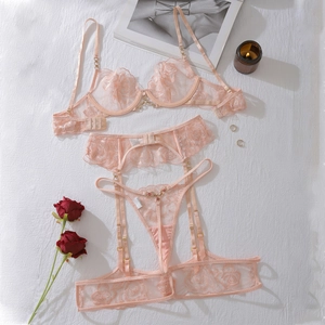 Vue détaillée de broderie florale rose et lingerie en dentelle avec détails de chaînes dorées