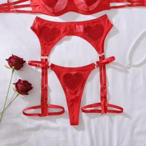 Détail d'un ensemble de lingerie en mesh rouge avec sequins cœur, porte-jarretelles et string