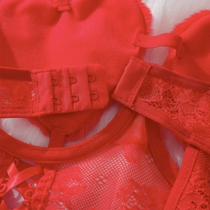 Detail von roter Spitzenunterwäsche mit Rückenverschluss und Plüsch-Herz-Akzenten