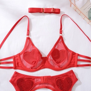 Ensemble de lingerie en résille rouge avec appliqués cœur et accessoires dorés sur tissu