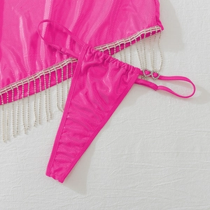 Détail de lingerie rose vif avec franges en strass et boucle cœur sur tissu résille