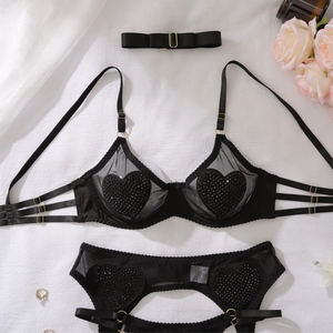 Détail d'ensemble de lingerie en tulle noir avec cœurs pailletés et boucles dorées
