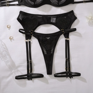 Détail d'un ensemble de lingerie en mesh noir avec strass en cœur et porte-jarretelles