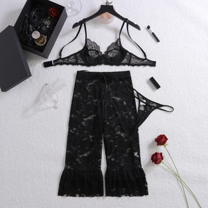 Draufsicht auf schwarzes Spitzen-Dessous-Set mit weiter Hose und floraler Deko