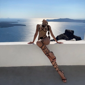 Detail of mesh halter lingerie with heart charm and lace-up stiletto sandals