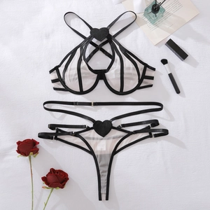 Flat lay of sheer white mesh lingerie set with black contrast trim and heart details