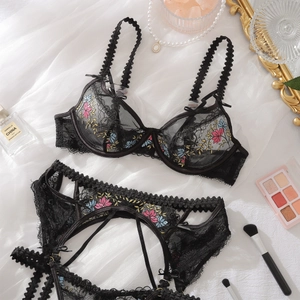 Detailed embroidery of colorful flowers on black lace lingerie with mesh fabric texture