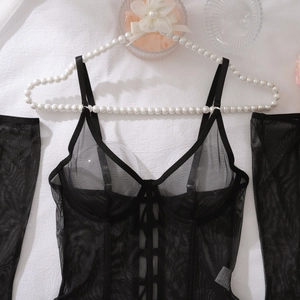 Detail of sheer black mesh lingerie set with lace-up front and matching arm sleeves