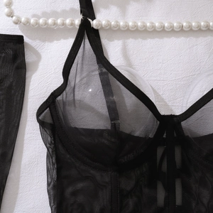 Close-up of black sheer mesh lingerie with delicate straps and fine texture detail