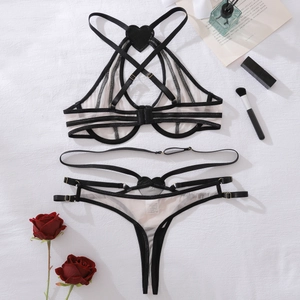 Detailed flat lay of mesh lingerie set with black heart patterns and strappy neck details