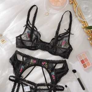 Close-up of black mesh lingerie set with colorful floral embroidery and scallop lace