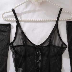 Detail of sheer black mesh lingerie set with lace-up ties on white pearl hanger