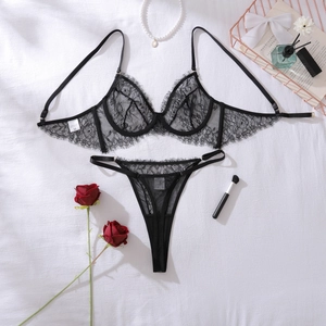 Flat lay of black eyelash lace lingerie set with red rose and pearl necklace