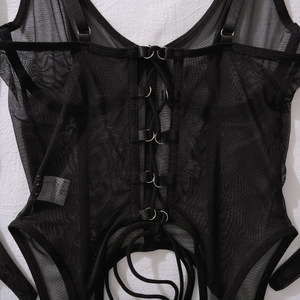 Close-up of black sheer mesh corset with lace-up metal ring detail and S-size tag