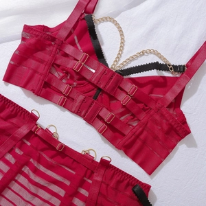 Détail d'un ensemble de lingerie en résille rouge avec chaînes dorées et agrafes