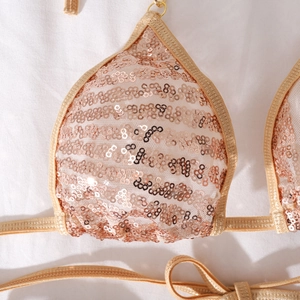 Detail eines champagnergoldenen Pailletten-Bikini-Tops mit gewebten Bändern