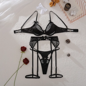 Détail à plat d'un ensemble de lingerie en dentelle noire avec porte-jarretelles sur soie
