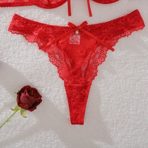 Detail of red floral lace T-back panty with a satin bow and metallic pendant detail