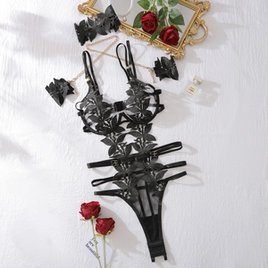 Dettaglio body in pizzo nero con catene dorate e decorazioni floreali di rose