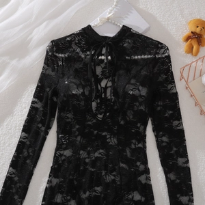 Detail of black floral lace fabric with lace-up neck design and sheer texture
