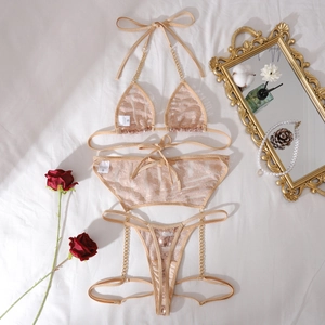 Detailaufnahme von champagnerfarbenem Pailletten-Lingerie-Set mit Ketten und Spitze