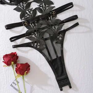 Dettaglio della giarrettiera in pizzo floreale nero con anelli dorati e cinghie elastiche