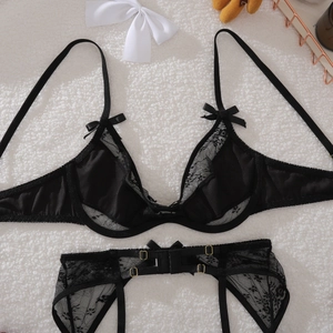 Vue détaillée d'un ensemble lingerie en dentelle noire avec boucles dorées et nœuds