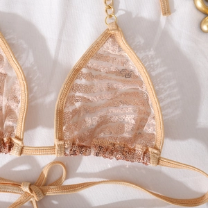 Detailansicht eines goldenen Spitzen-Bikinioberteils mit Ketten-Trägern und glänzenden Pailletten