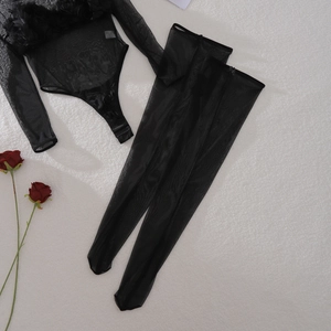 Detail of sheer black mesh bodysuit featuring 3D rose appliqués and matching stockings