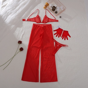 Ensemble lingerie en tulle rouge avec pantalon large et gants sur un tapis en peluche