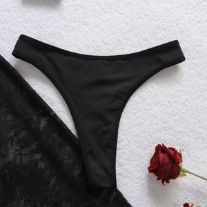 Dettaglio di lingerie in pizzo nero con occhielli in metallo su sfondo di peluche bianco